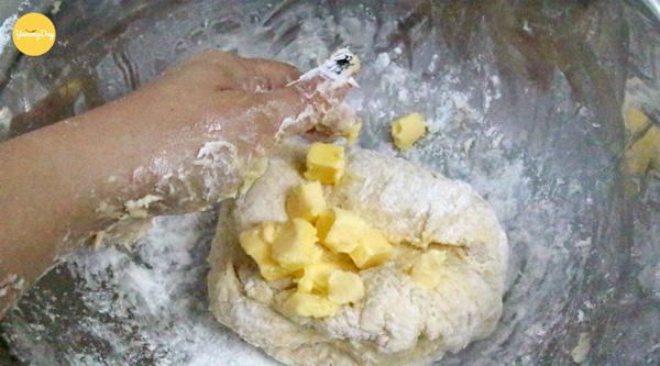Cho bơ mềm vào và tiếp tục nhồi bột