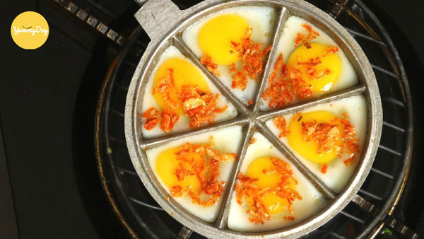 Đập trứng vào khuôn và cho thêm tép khô vào